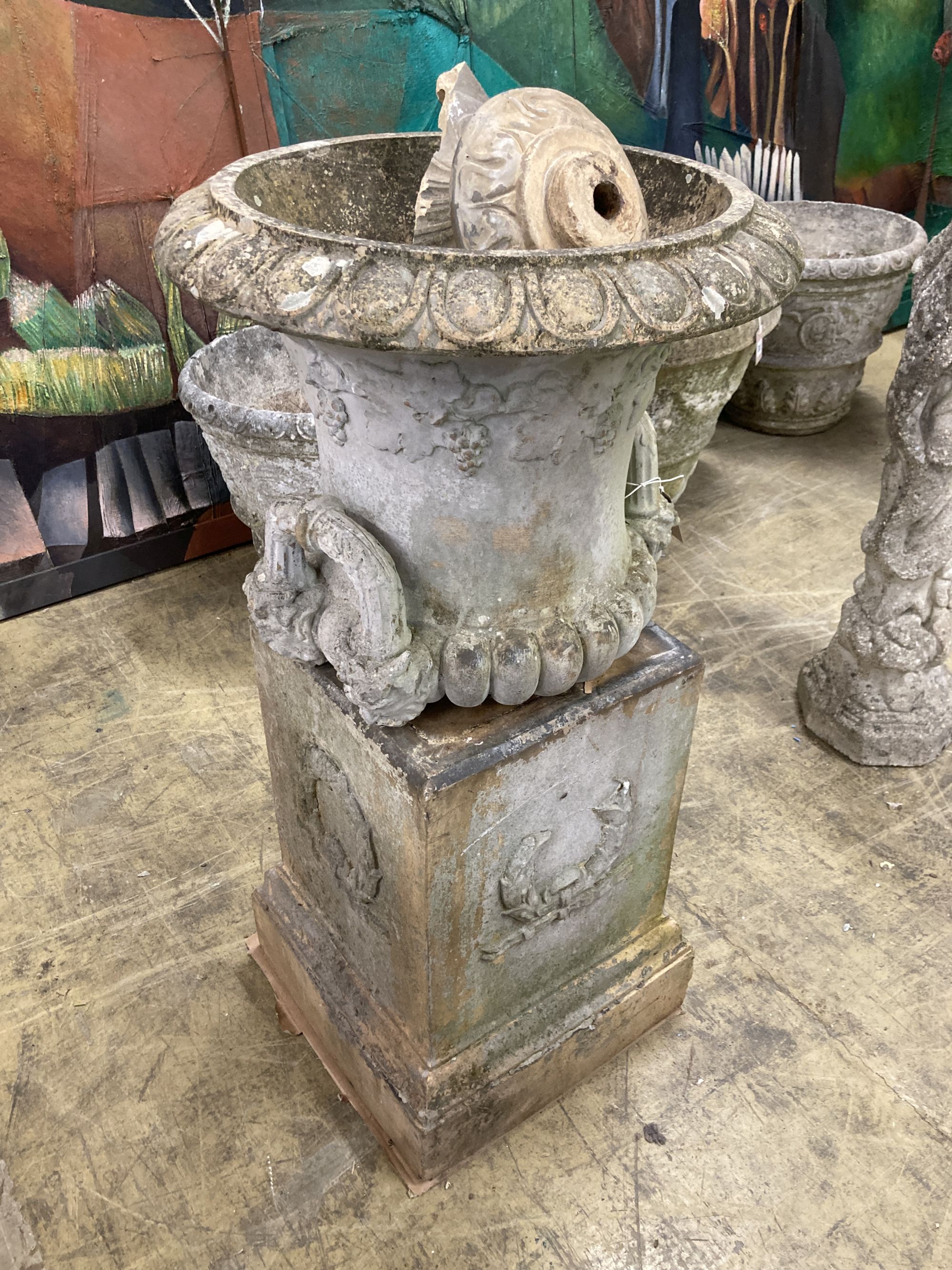 A painted earthenware campana garden urn on square plinth, (in need of repair) 53cm diameter, height 100cm